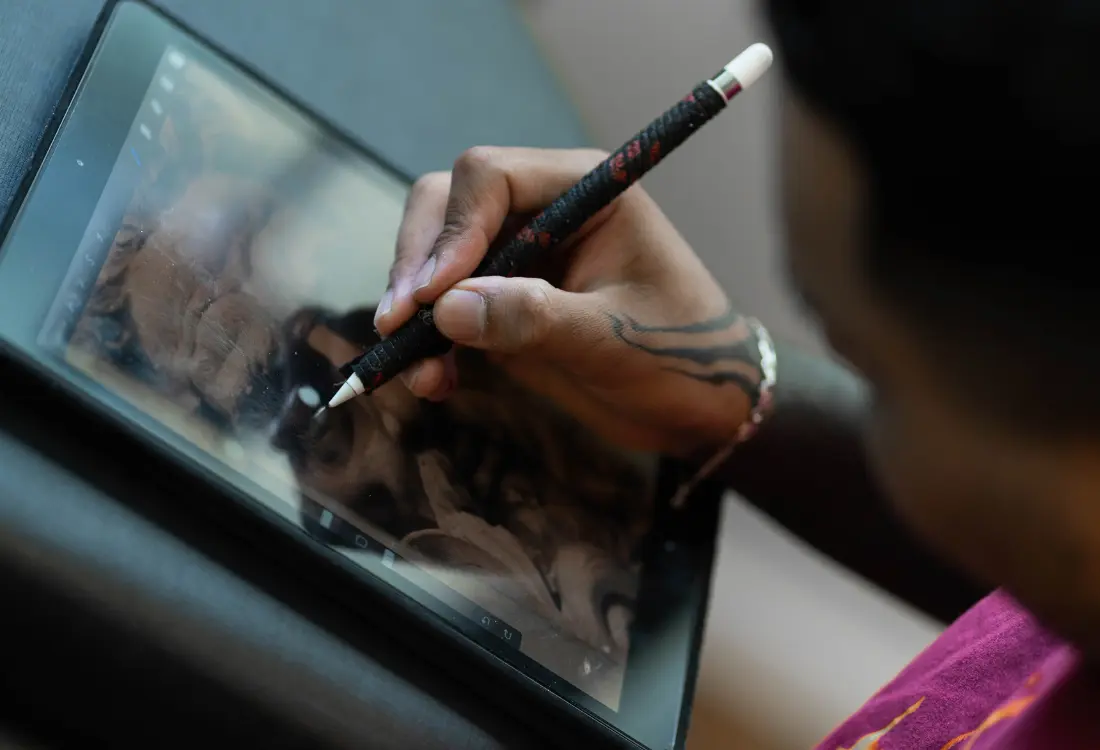 Designer creating digital painting and screen printing artwork on a drawing tablet before custom t shirt printing.
