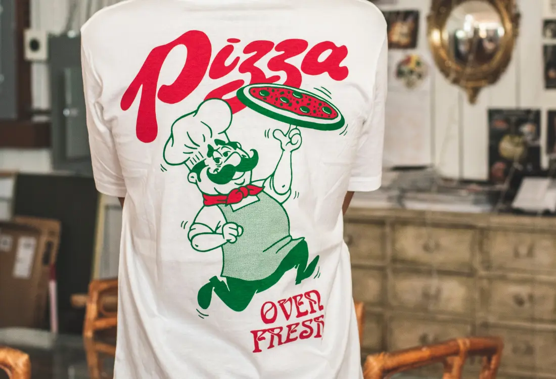 Restaurant merchandise featuring a custom printed pizza restaurant t-shirt with a bold graphic back design.
