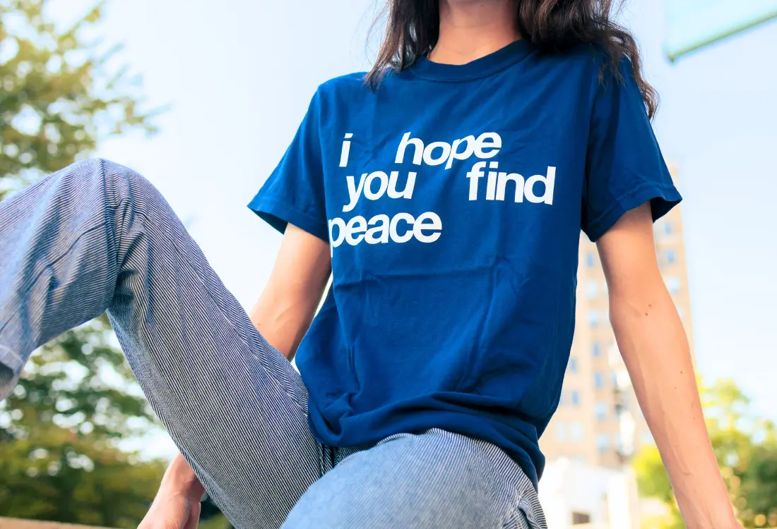 Person wearing a blue slogan t-shirt with a positive message, showing how statement clothing communicates ideas through fashion.