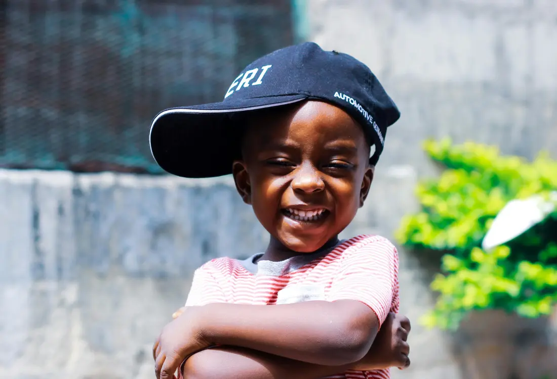 Child wearing a navy embroidered baseball cap with a small front logo as an example of custom cap embroidery.