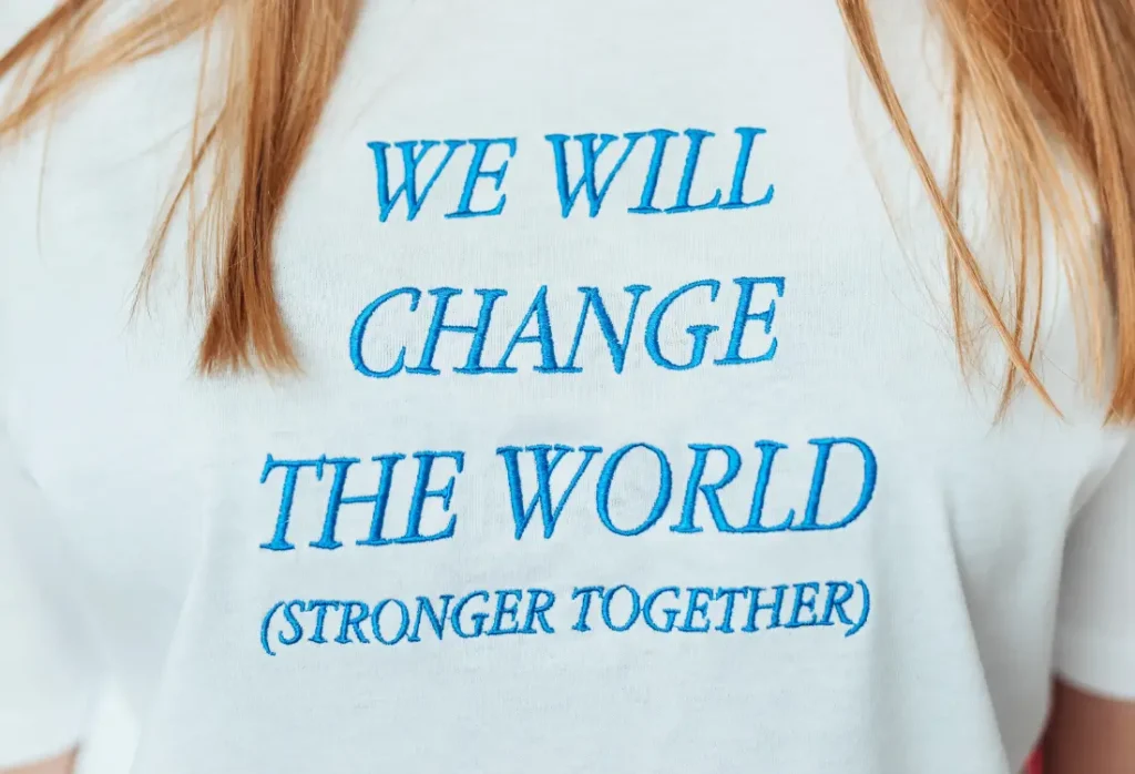 Close-up of logo embroidery on a white embroidered t shirt with premium blue stitching and clean lettering.