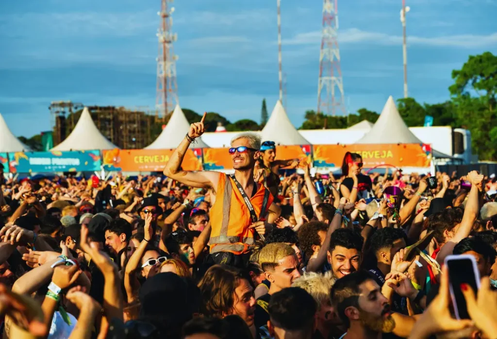 Festival t shirt styled with a waist bag and boots, ready for crowds, night sets and unpredictable weather, combining comfort, protection for feet, and a cool outfit that works from planning to the final encore.