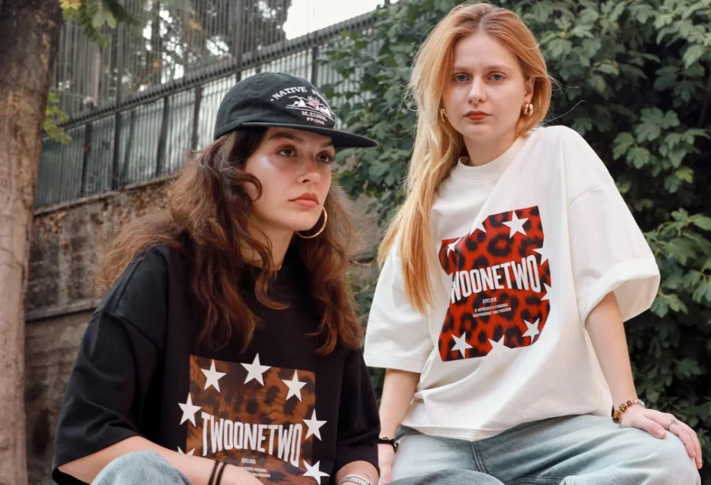 Gen z'ers wearing cool oversized graphic T-shirts with baggy denim and a casual Gen Z style.